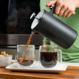 Pouring coffee from the French Press into a glass mug